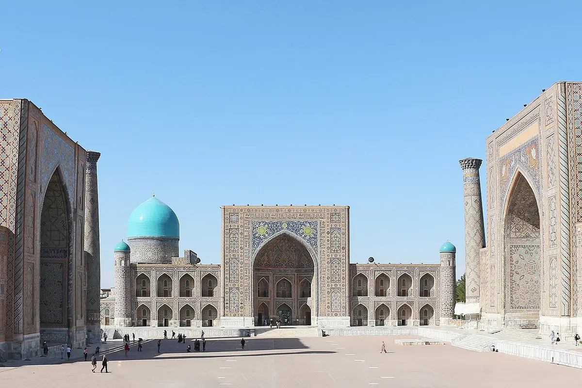 Der Registan-Platz in Samarkand mit der Tilya-Kori-Madrasa und ihrer türkisfarbenen Kuppel im Zentrum sowie den Madrasas Ulugh Beg und Sherdar zu beiden Seiten
